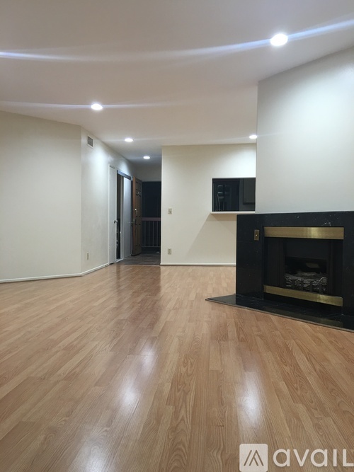 A room with a fireplace and wooden flooring.