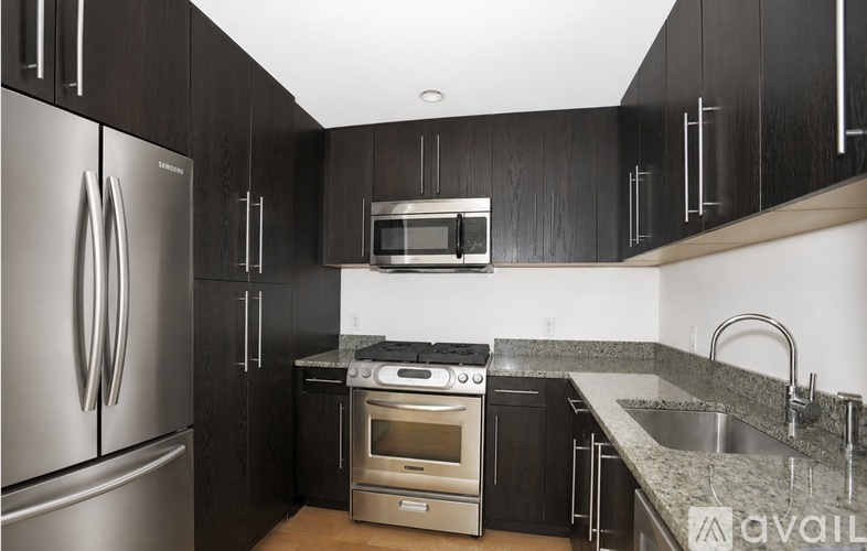 A kitchen with black cabinets and stainless steel appliances.