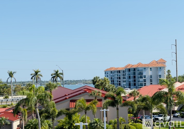 A view of a resort with a large building in the background and palm trees in the foreground.