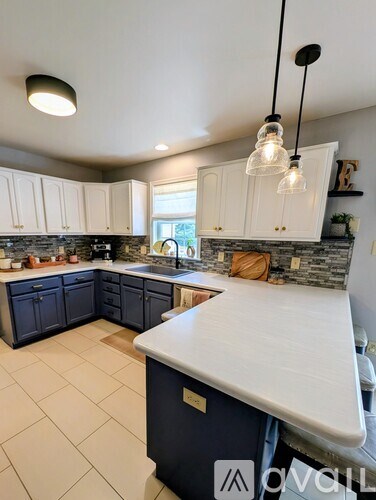 A kitchen with white cabinets and a blue island.