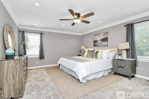 A bedroom with a bed, nightstand, and a dresser with a mirror.