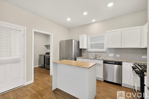 A kitchen with white cabinets and a wooden island.