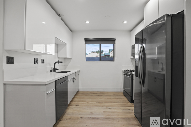 A modern kitchen with a large window and a washing machine.