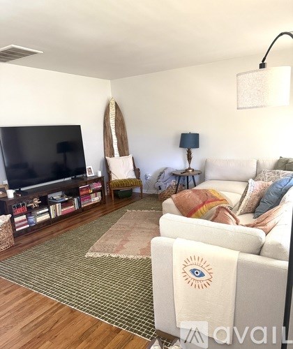 A living room with a white couch and a rug.