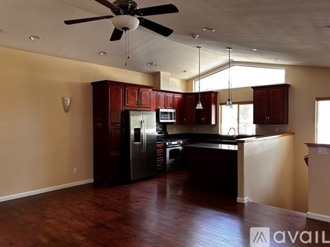 A kitchen with wooden cabinets and a ceiling fan.