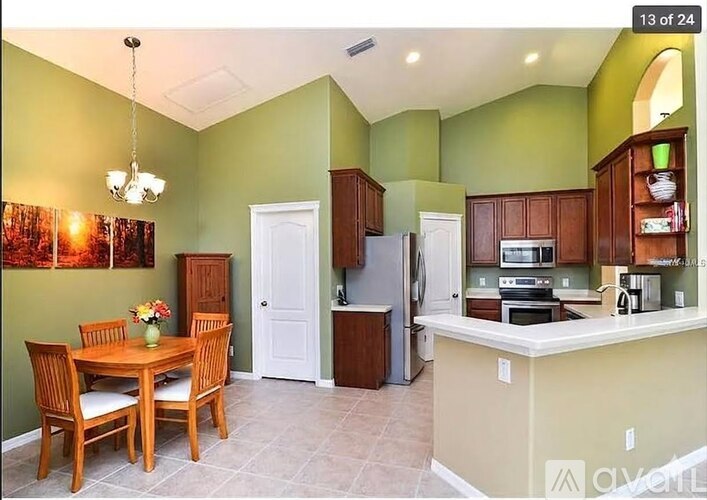 A kitchen with green walls and a table set for two.