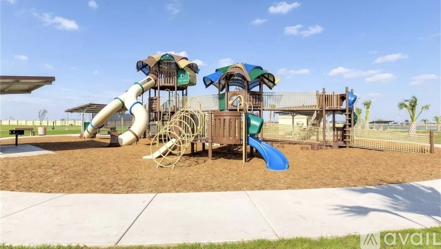 A playground with a blue slide and a wooden structure.