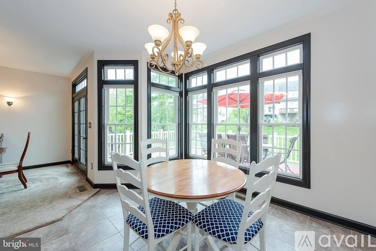 A dining room with a table and chairs and a chandelier.