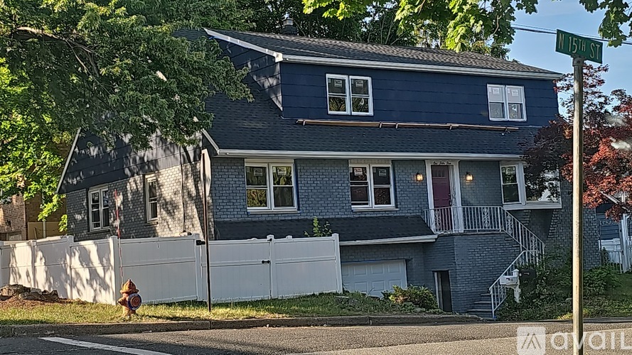 A blue house with a white fence and a red fire hydrant in front.