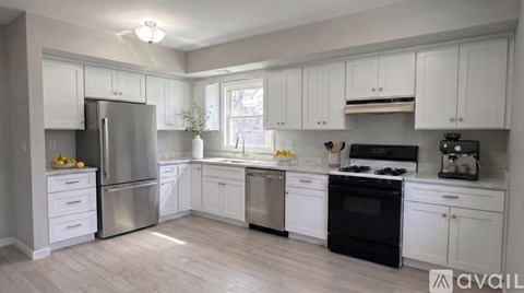 A kitchen with white cabinets and stainless steel appliances.