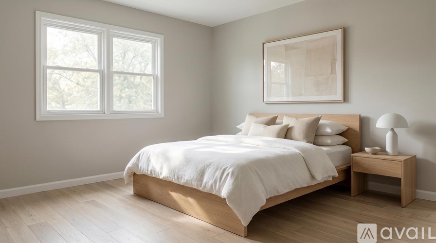 A bedroom with a bed, nightstand, and window.