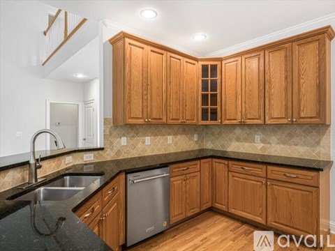 A kitchen with wooden cabinets and a black countertop.