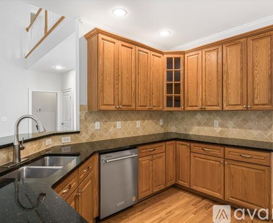 A kitchen with wooden cabinets and a black countertop.