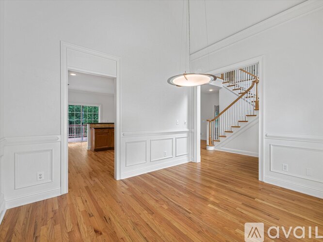 A spacious room with wooden floors and white walls.