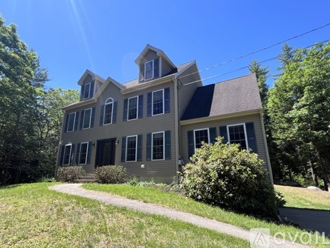 A two-story house with a grey exterior and a black roof.