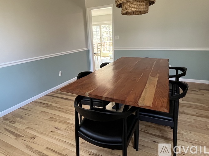 A dining room with a wooden table and chairs.