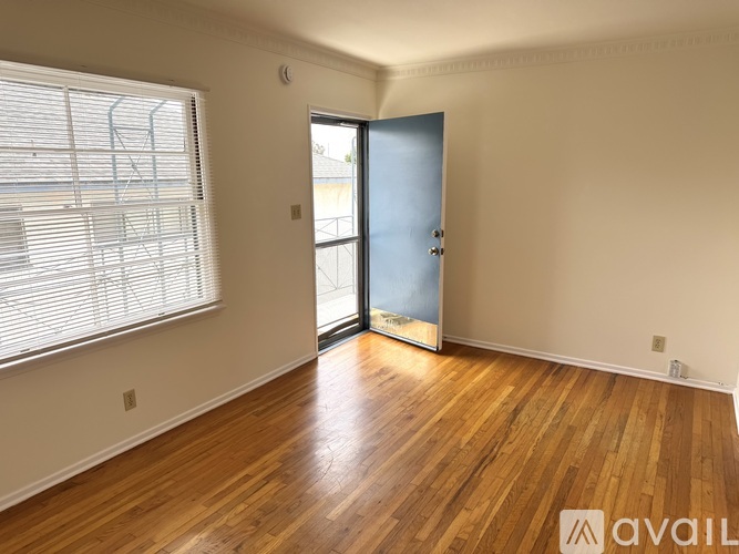 A room with a blue door and wooden flooring.