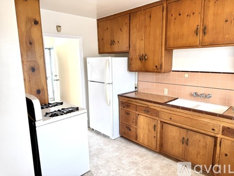 A kitchen with wooden cabinets and a white fridge.