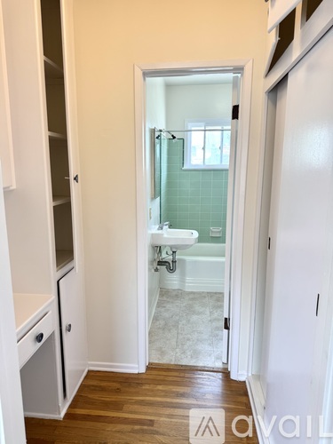 A bathroom with a white cabinet and a glass shower door.