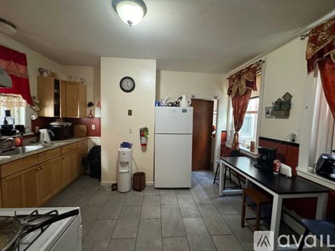 A kitchen with a white refrigerator and a stove top oven.