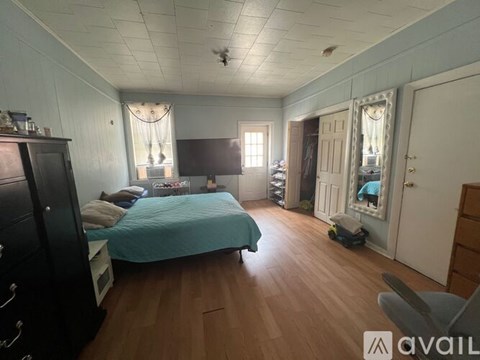 A bedroom with a bed, dresser, and mirror.