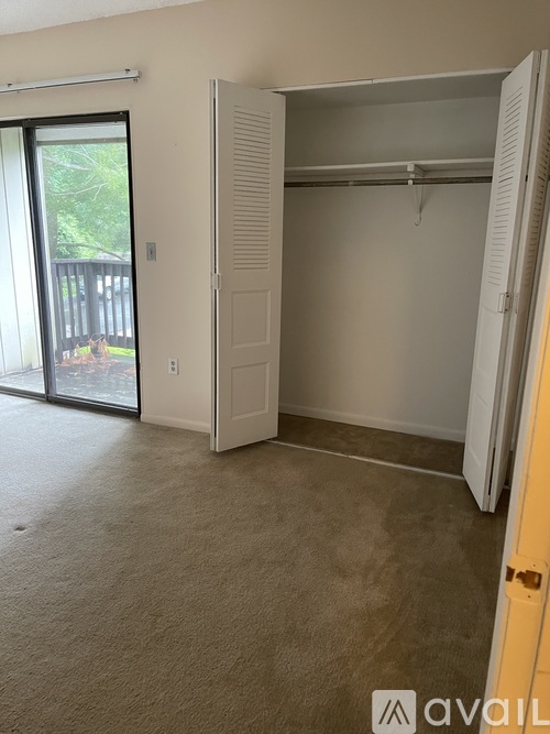 A bedroom with a large closet and sliding glass doors.