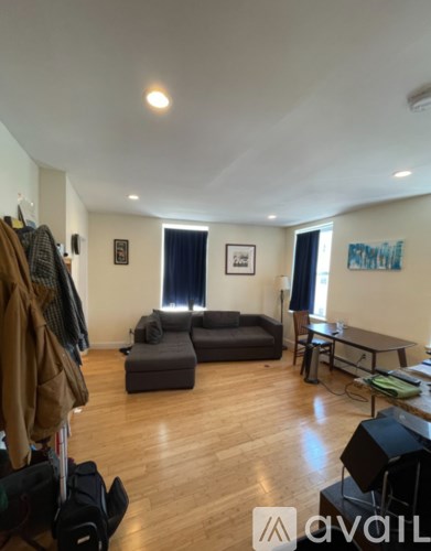 A living room with a grey couch and a black chair.