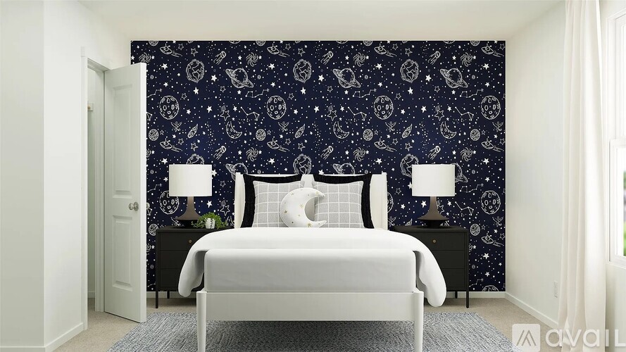 A bedroom with a white bed and a wallpapered wall with a starry night scene.