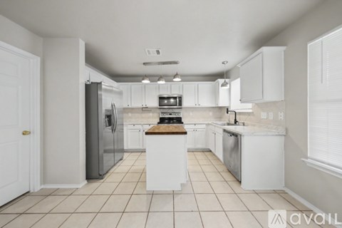 A kitchen with white cabinets and appliances.