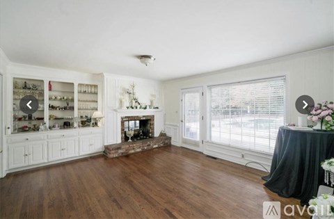 A living room with a fireplace and a dining table.