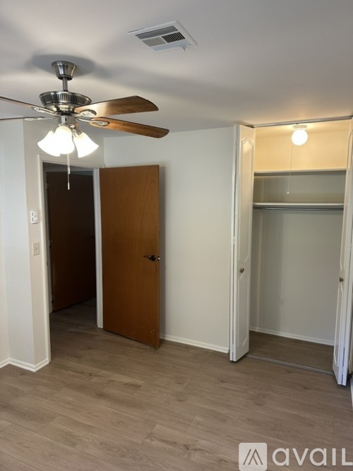 A room with a ceiling fan and a door.