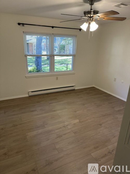 A room with a window and a ceiling fan.