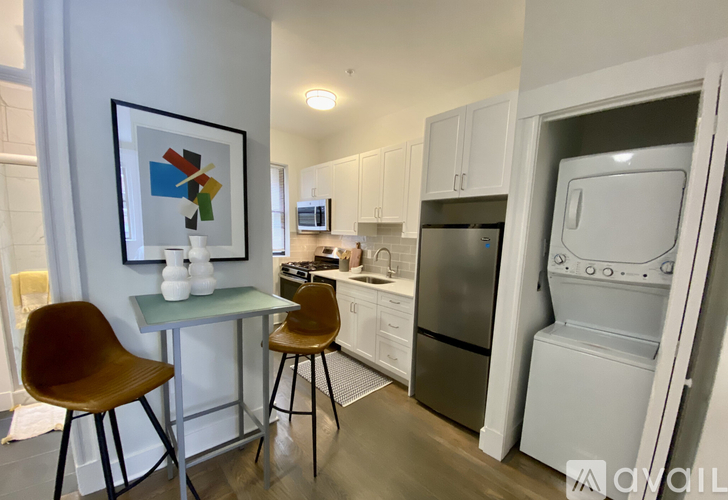 A kitchen with a refrigerator, microwave, and oven.