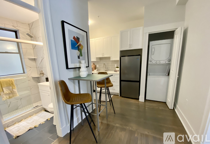A kitchen with a table and chairs and a fridge.