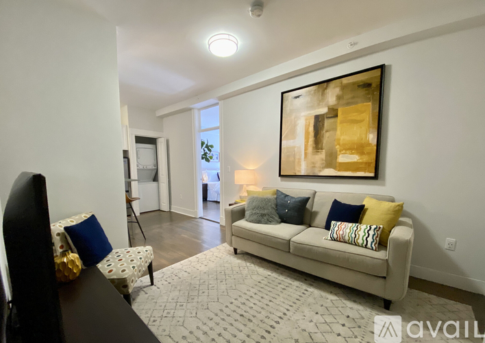 A living room with a couch, chair, and painting on the wall.