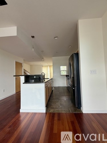 A kitchen with white cabinets and a black counter top.
