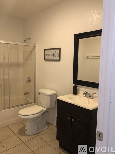 A white toilet sits next to a sink in a bathroom.