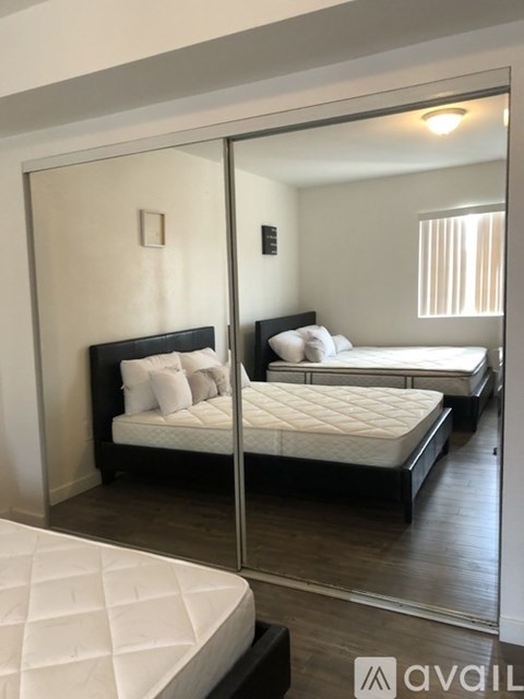 A bedroom with a large bed and a mirror on the wall.