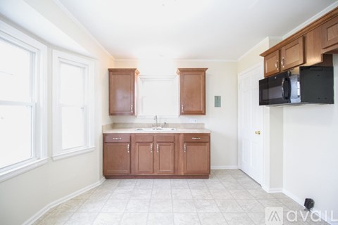 A kitchen with brown cabinets and white walls.