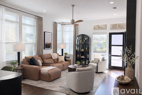 A modern living room with a brown sofa and a glass door.