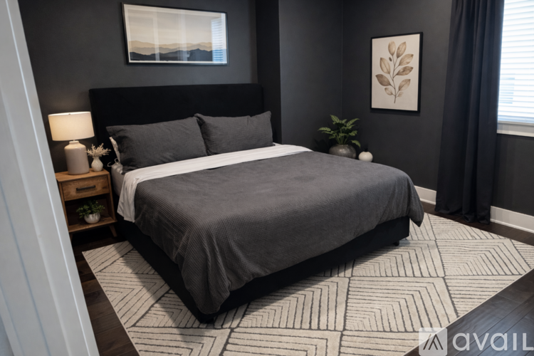 A bedroom with a large bed and a painting on the wall.