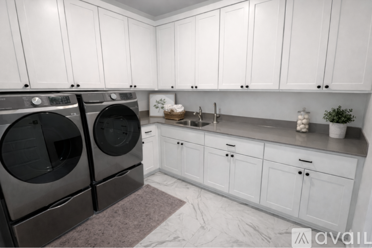 A modern kitchen with white cabinets and a marble floor.