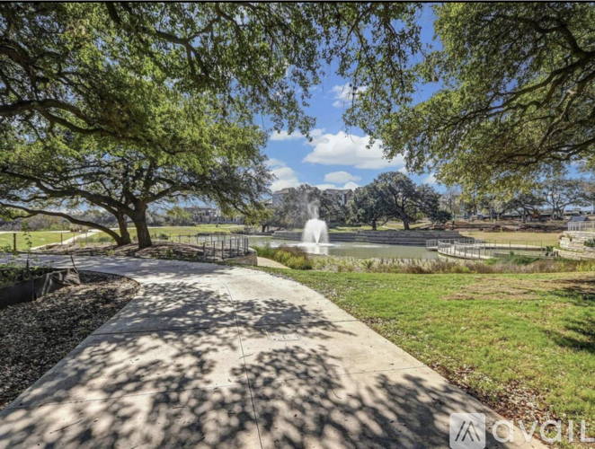 A park with a fountain and trees.