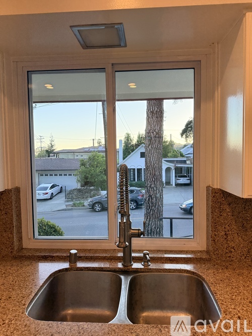 A kitchen sink with a window overlooking a street.
