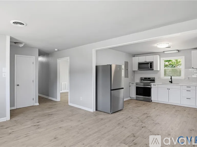 A kitchen with white cabinets and a stainless steel refrigerator.