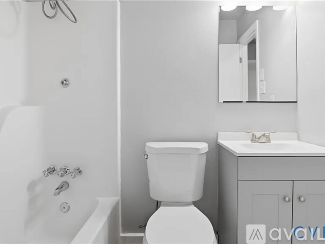 A white toilet in a bathroom with a white sink and a mirror.