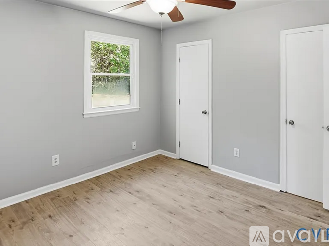 A room with a ceiling fan and two doors.