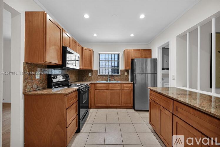 A kitchen with wooden cabinets and a granite countertop.