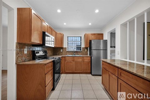A kitchen with wooden cabinets and a granite countertop.