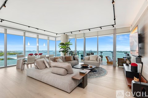 A living room with a large couch and a view of the water.